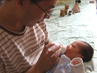 宝宝爸爸在给小宝宝喂奶呢。